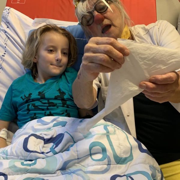 Villads og hospitalsklovnen Karla i en hospitalsseng og folder en serviet