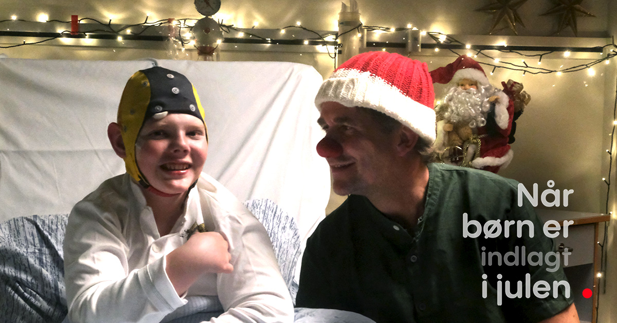 Kalle sidder i en hospitalsseng med hospitalssklovnen Makaroni ved sin side