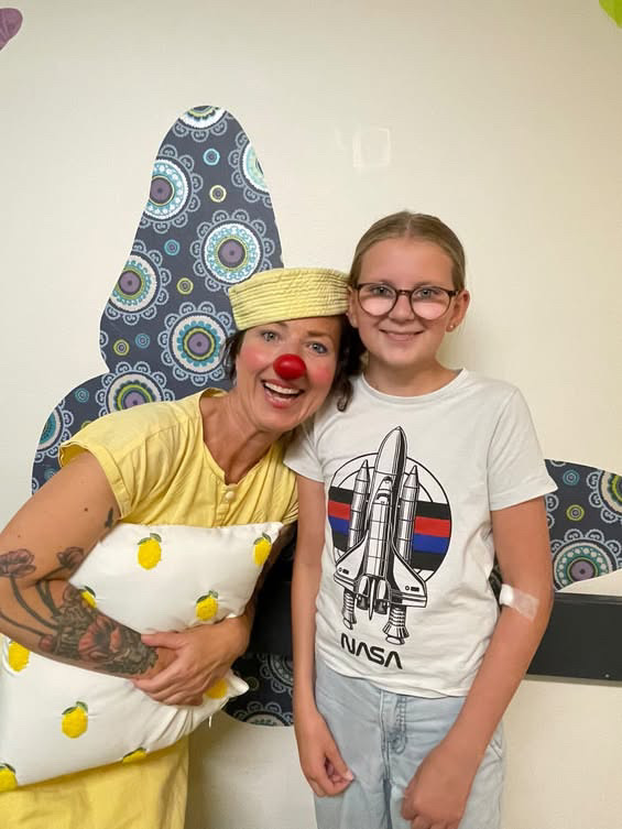 Hospitalsklovnen Citronella står ved siden af pigen Signe